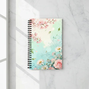 Floral spiral notebook with cherry blossoms, daisies, and roses on a marble surface
