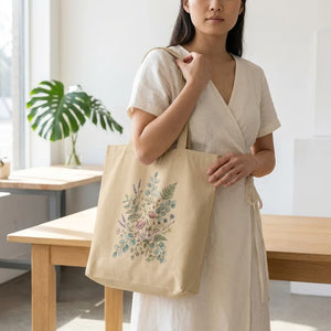 Woman holding a beige tote bag with pastel floral design, standing in a sunlit home.