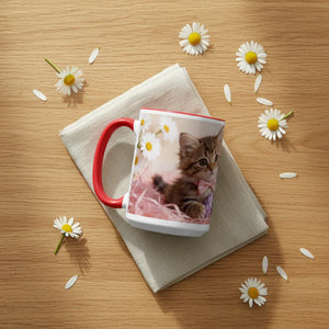 Ceramic mug with kitten and daisies design on napkin, surrounded by daisy flowers on wood table