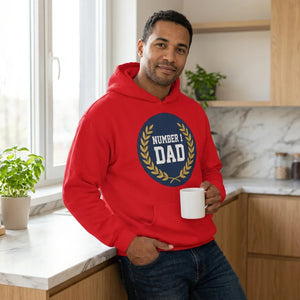 Man in red 'Number 1 Dad' hoodie holding coffee mug in modern kitchen