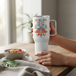 Hand holding a white travel mug with 'World's Best Mom' floral design on a wooden table