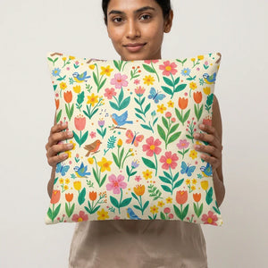 Woman holding a decorative throw pillow with colorful floral and bird pattern on cream background
