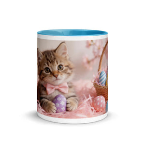 White ceramic mug with blue interior, featuring a kitten and Easter eggs design on the front.