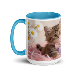 White ceramic mug with blue handle and interior, featuring a kitten and daisies illustration
