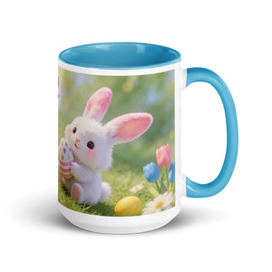 White ceramic mug with blue handle and interior, featuring a cute bunny holding a decorated Easter egg among colorful spring flowers.