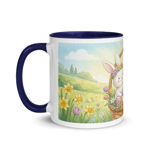 White ceramic mug with dark blue handle and rim, featuring a cute bunny in a flower basket illustration