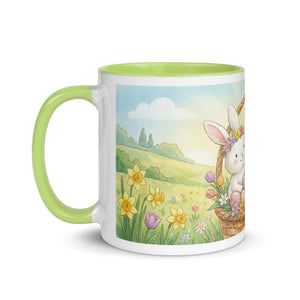 White ceramic mug with green handle, featuring a cute bunny in a flower basket and spring meadow scene