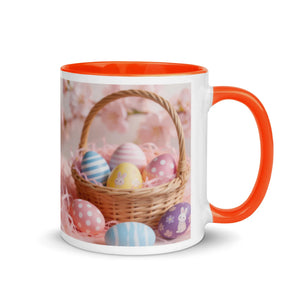 White ceramic mug with orange interior and handle, featuring a basket of colorful Easter eggs.