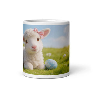 White ceramic mug featuring a cute lamb with a pink bow and an Easter egg on green grass