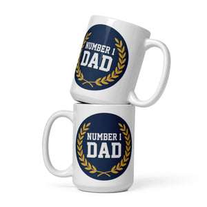 White glossy mugs stacked, each with a blue 'Number 1 Dad' design and gold wreath accent.