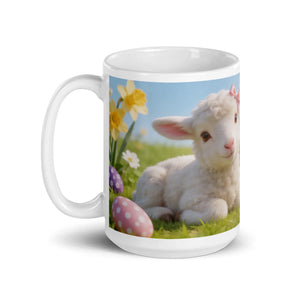 White ceramic mug with Easter lamb, daffodils, and decorative eggs design on grass