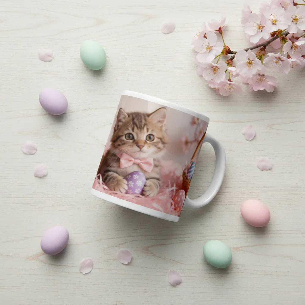 Ceramic mug with a cute kitten in a pink bow and Easter egg, surrounded by pastel eggs and cherry blossoms.