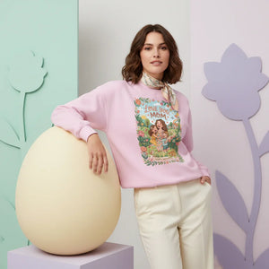 Woman in pink "Love you Mom" graphic sweatshirt, white pants, floral pastel background