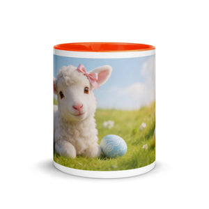 White ceramic mug with orange interior, featuring a cute lamb with a pink bow and Easter egg on grass