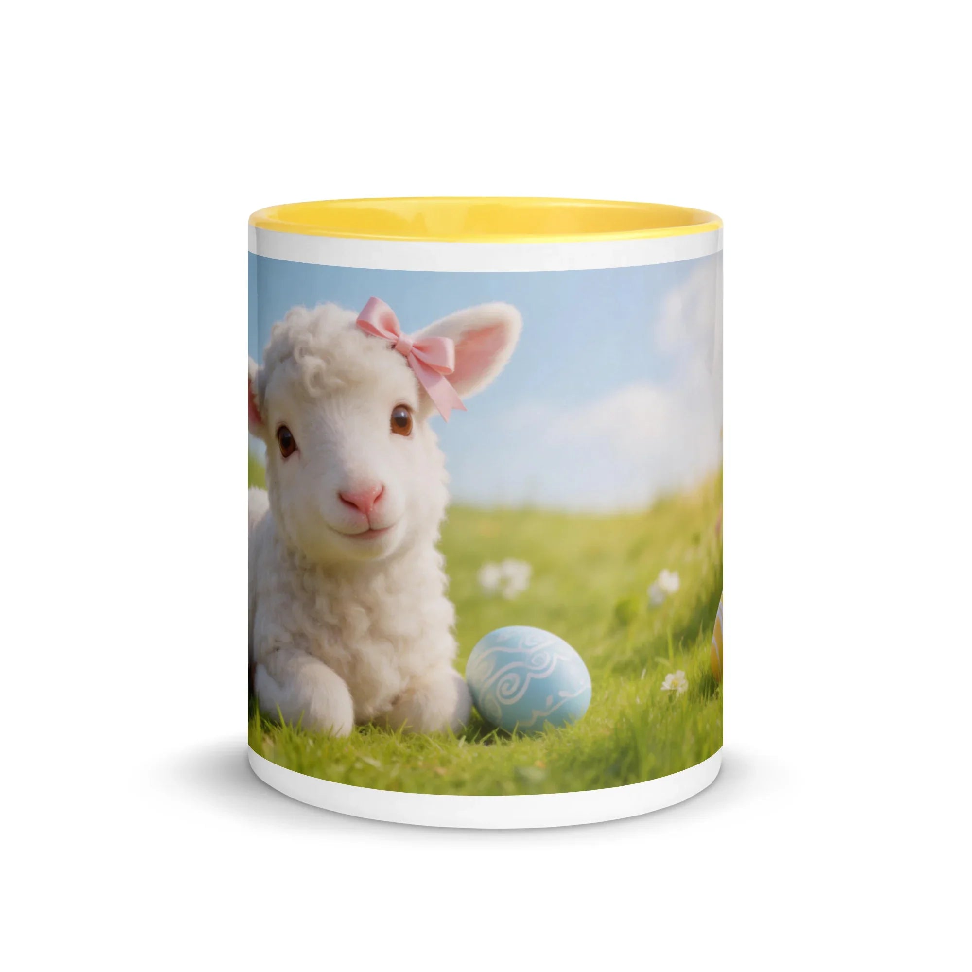 White ceramic mug with yellow interior, featuring a cute lamb with pink bow and Easter egg design on grassy field
