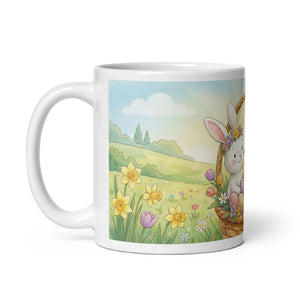 White ceramic mug with cute bunny in a flower basket and spring meadow illustration